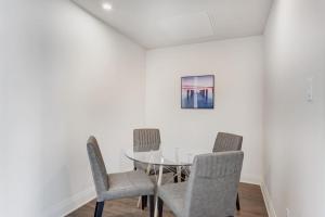 ein Esszimmer mit Glastisch und Stühlen in der Unterkunft Corporate Stays Equinoxe 1 Bedroom in Chomedey