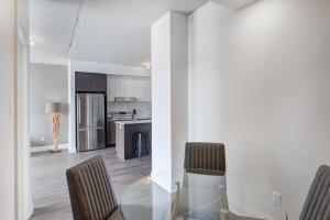 eine Küche und ein Esszimmer mit einem Glastisch und Stühlen in der Unterkunft Corporate Stays Equinoxe 1 Bedroom in Chomedey