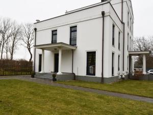 un edificio blanco con un campo de hierba delante de él en Ferienwohnung Parkblick, en Poseritz