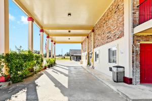 un edificio vuoto con porte rosse e un muro di mattoni di Jeffersonian Motor Inn by Townhouse, Prentiss MS a Prentiss