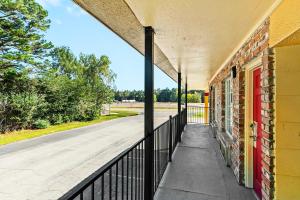 un edificio vuoto con una recinzione nera accanto a una strada di Jeffersonian Motor Inn by Townhouse, Prentiss MS a Prentiss