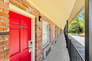 una porta rossa sul lato di un edificio in mattoni di Jeffersonian Motor Inn by Townhouse, Prentiss MS a Prentiss