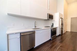 eine Küche mit weißen Schränken und Geräten aus Edelstahl in der Unterkunft Corporate Stays Jade 1 Bedroom in Halifax