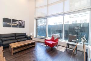 ein Wohnzimmer mit einer Couch und einem roten Sessel in der Unterkunft Corporate Stays Jade 1 Bedroom in Halifax