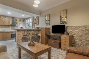ein Wohnzimmer mit Fernseher und eine Küche in der Unterkunft Casa Ignacio a 15 minutos de Ronda in Arriate