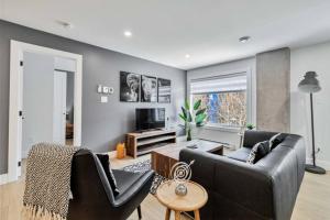 a living room with a couch and a tv at Corporate Stays Millennium Boulevard 1 Bedroom in Moncton