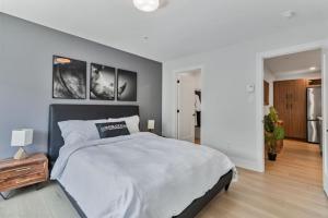 a bedroom with a large bed and a wall with pictures at Corporate Stays Millennium Boulevard 1 Bedroom in Moncton