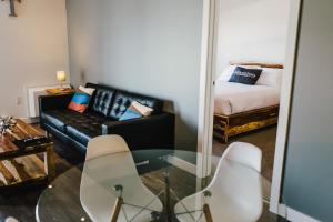 ein Wohnzimmer mit einer Couch und einem Glastisch in der Unterkunft The Spot - Furnished 2 Bedrooms Rental in Winnipeg's Tuxedo in Tuxedo
