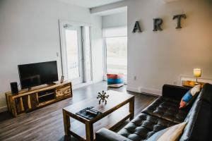ein Wohnzimmer mit Sofa und Fernseher in der Unterkunft The Spot - Furnished 2 Bedrooms Rental in Winnipeg's Tuxedo in Tuxedo