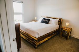 ein Schlafzimmer mit einem Bett mit weißen Laken und einem Fenster in der Unterkunft The Spot - Furnished 2 Bedrooms Rental in Winnipeg's Tuxedo in Tuxedo