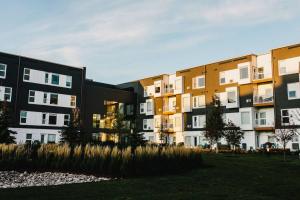 eine Reihe von Apartmenthäusern mit Gras im Vordergrund in der Unterkunft The Spot - Furnished 2 Bedrooms Rental in Winnipeg's Tuxedo in Tuxedo