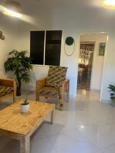 a living room with a wooden table and a chair at Beach house villa in Kokrobite