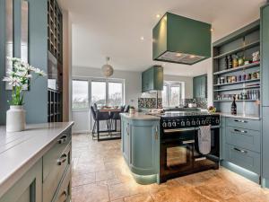 a kitchen with green cabinets and a stove at 3 Bed in Chale 94165 in Chale