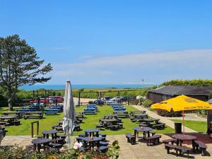 a group of tables and chairs with umbrellas at 3 Bed in Chale 94165 in Chale