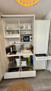 eine Küche mit Spüle und Mikrowelle in der Unterkunft ATOUMO vue mer avec cuve in Saint-François