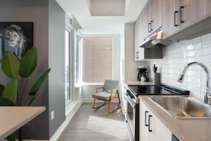 eine kleine Küche mit einem Waschbecken und einem Waschbecken in der Unterkunft The Lennox Pet Friently 2 Bedroom Rental in Ottawa 613 in Ottawa
