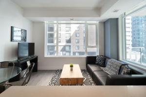 ein Wohnzimmer mit Sofa und Tisch in der Unterkunft The Lennox Pet Friently 2 Bedroom Rental in Ottawa 613 in Ottawa