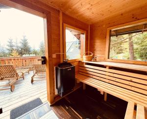 a porch of a wooden cabin with a television on it at ALMNEST - LACHTAL in Lachtal +58 photos