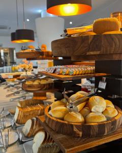 a buffet of bread and pastries on a table at Favorita Golden Hotel e Eventos in São José
