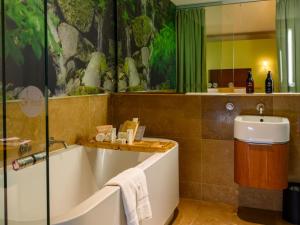 a bathroom with a bath tub and a sink at Ohtel Wellington in Wellington