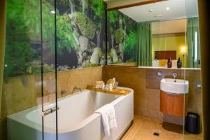 a bathroom with a bath tub and a sink at Ohtel Wellington in Wellington