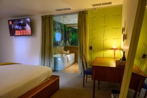 a bedroom with a bed and a desk and a bathroom at Ohtel Wellington in Wellington