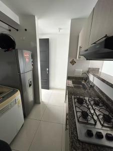 a small kitchen with a stove and a refrigerator at Apto de 1 Habitación - Vista, Frescura, Buen Ambiente y cerca de todo in Bucaramanga