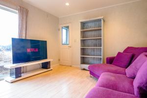ein Wohnzimmer mit einem lila Sofa und einem TV in der Unterkunft TOCORO, MT,FUJI Mutsuki - Vacation STAY 03957v in Funatsu