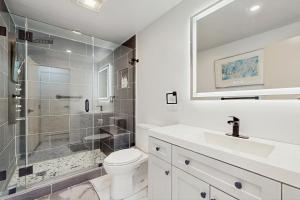 a bathroom with a shower and a toilet and a sink at Twin Ponds in Oak Bluffs +15 photos