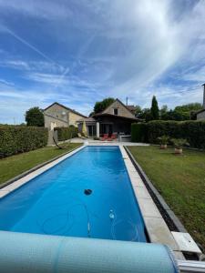 a large blue swimming pool in front of a house at Le Mas de Laché in Caylus
