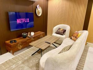 a living room with a television and two chairs at The Rock Hostel in AlUla
