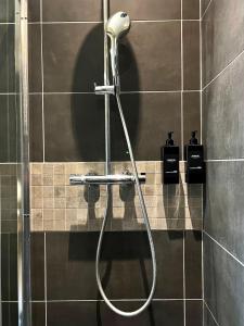 a shower with a hose in a bathroom at T1 lumineux & cosy, vue Cathédrale, Amiens centre in La Celle-sous-Gouzon