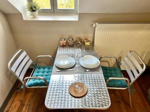 a table and chairs with a table and a hat on it at T1 lumineux & cosy, vue Cathédrale, Amiens centre in La Celle-sous-Gouzon +8 photos