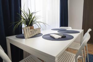 a white table with two remote controls on top at Casa Rusu - Govandari -Self check in-24h Netflix in Reşiţa