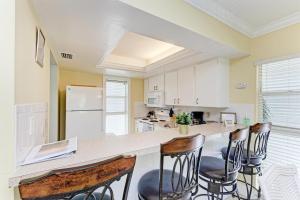 a kitchen with a counter with chairs around it at Beach Castle #18 in Longboat Key