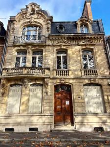 an old building with a wooden door and windows at T1 lumineux & cosy, vue Cathédrale, Amiens centre in La Celle-sous-Gouzon