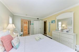 a bedroom with a large white bed with pink pillows at Beach Castle #18 in Longboat Key +29 photos