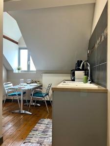 a kitchen and dining room with a table and chairs at T1 lumineux & cosy, vue Cathédrale, Amiens centre in La Celle-sous-Gouzon