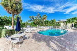 a patio with a table and chairs and a pool at Beach Castle #18 in Longboat Key