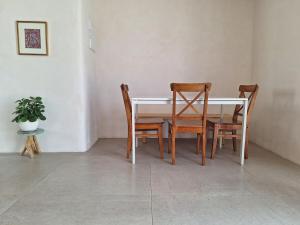 a dining room table with four chairs and a plant at מעיינות האהבה in Reshafim +14 photos