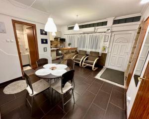 een keuken en eetkamer met een tafel en stoelen bij Zenora Apartman in Makó