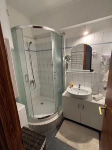 ein Badezimmer mit Dusche und Waschbecken in der Unterkunft Zenora Apartman in Makó + 11 Fotos