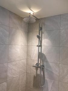 a shower with a shower head in a bathroom at The Bluebell in Helpston