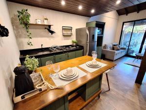 a kitchen with a table with plates and wine glasses at Loft Girassol in Palhoça