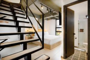 a room with a staircase and a bed and a bathroom at Hotel Attic 33 in Medellín
