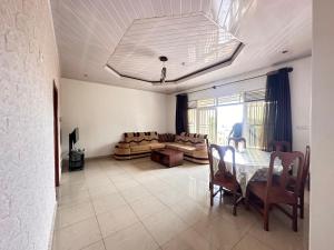 ein Wohnzimmer mit einem Tisch und einem Sofa in der Unterkunft EASY KIGALI STAY Apartment in Kigali