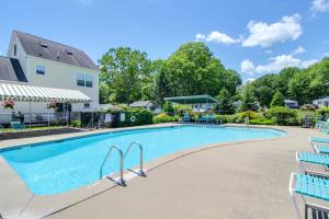 a swimming pool with blue chairs next to a house at Sparkling Sands Holiday House M2 in Moody