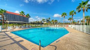 una piscina en un resort con palmeras en Gulf Views Pools Tennis Pickleball Beach Access Awesome Beachfront by AvantStay, en Mustang Beach