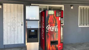 una máquina expendedora de coca cola junto a una máquina de refrescos en Studio 6 - Oakland, CA – San Francisco Berkeley Area, en Oakland