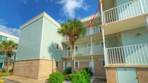 un edificio con palmeras delante en Gulf Views Pools Tennis Pickleball Beach Access Awesome Beachfront by AvantStay, en Mustang Beach